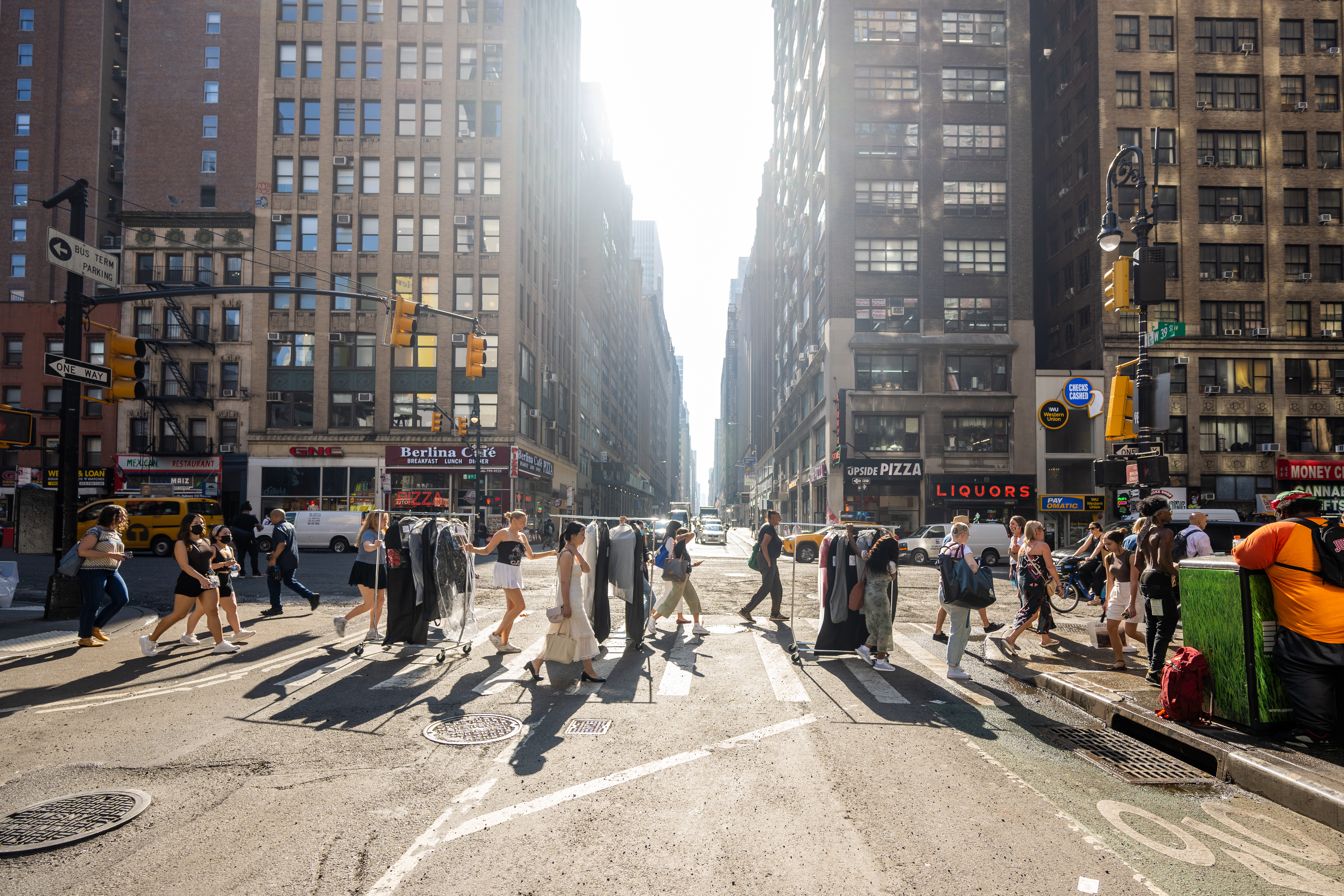 Tall buildings in a downtown setting rise over students crossing a walkway
