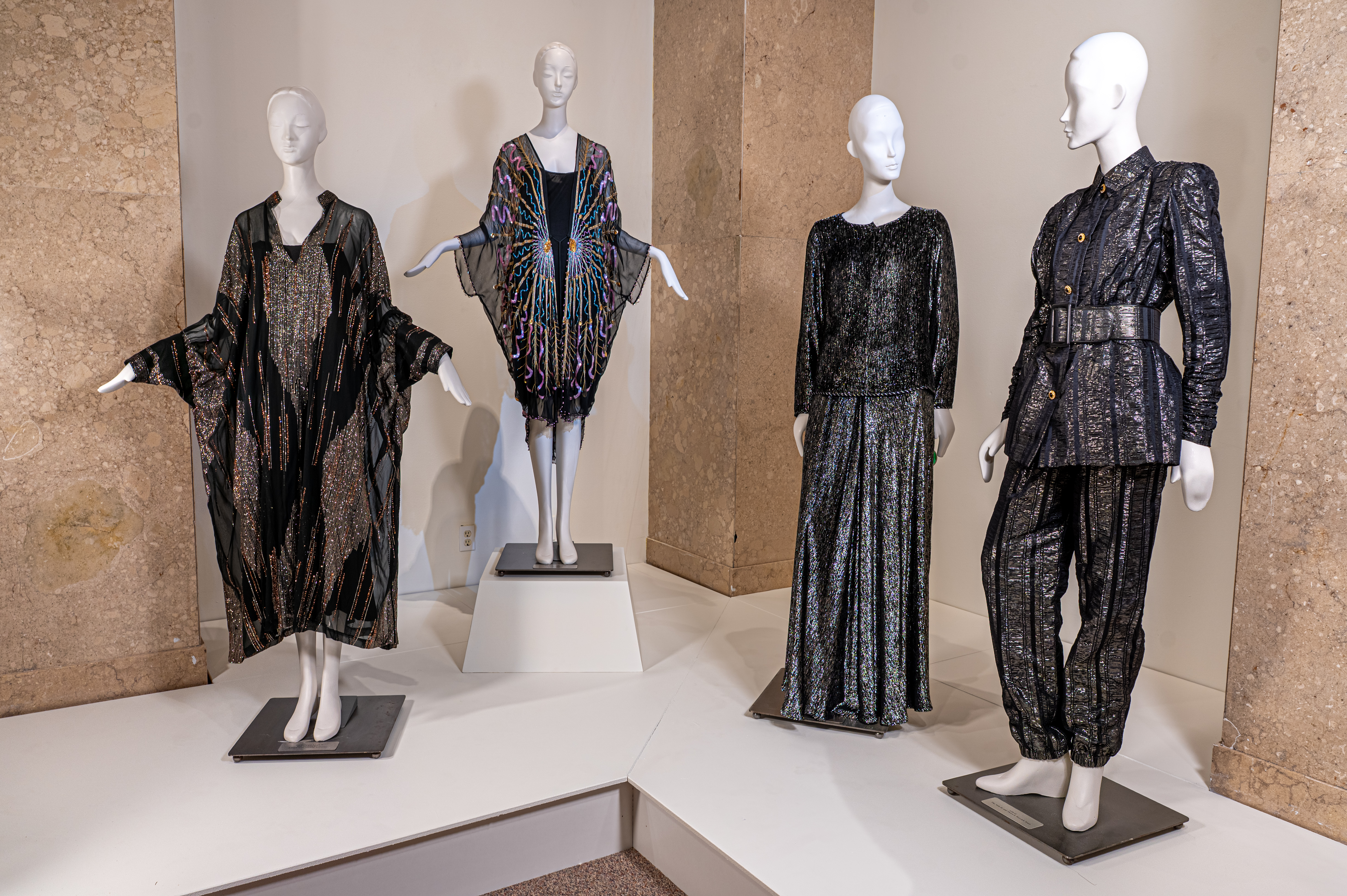 Sparkle Exhibition Four mannequins pose in various sparkling, dark chrome outfits