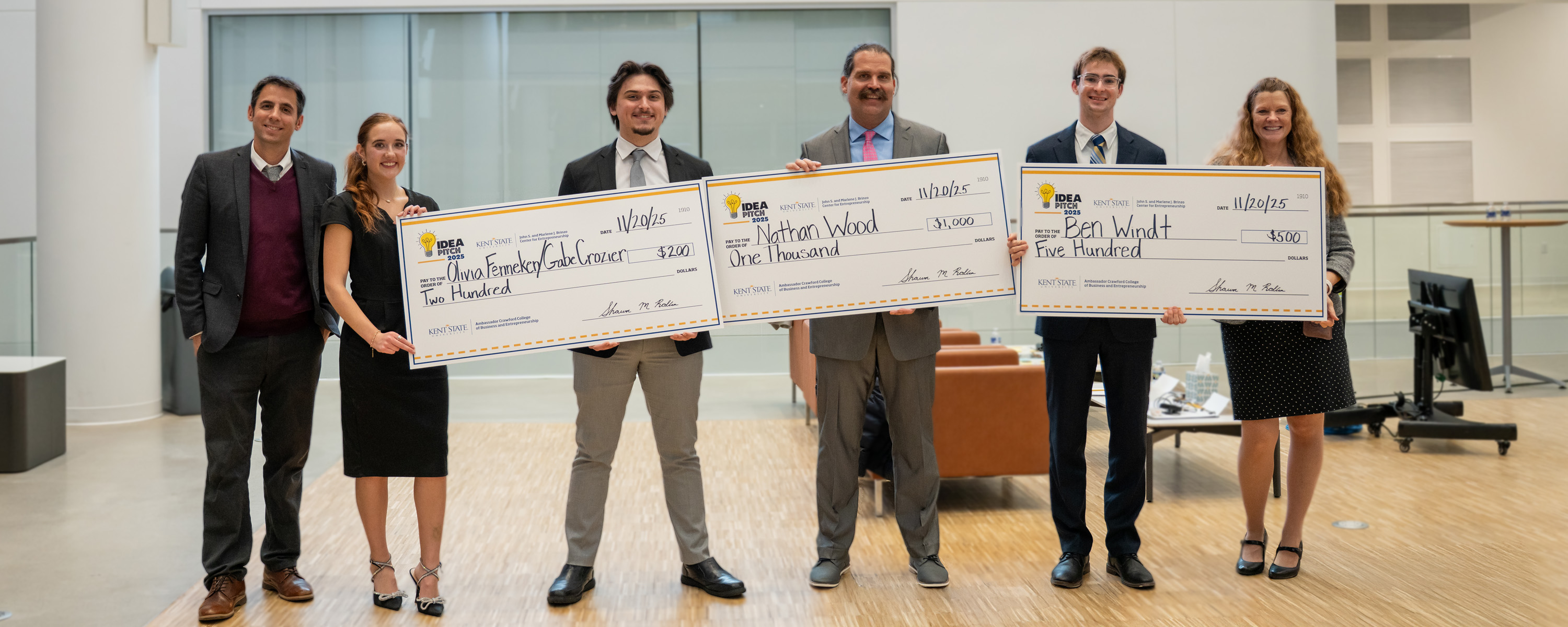 winnners of the 2025 idea pitch, posing with their advisors and large checks. 