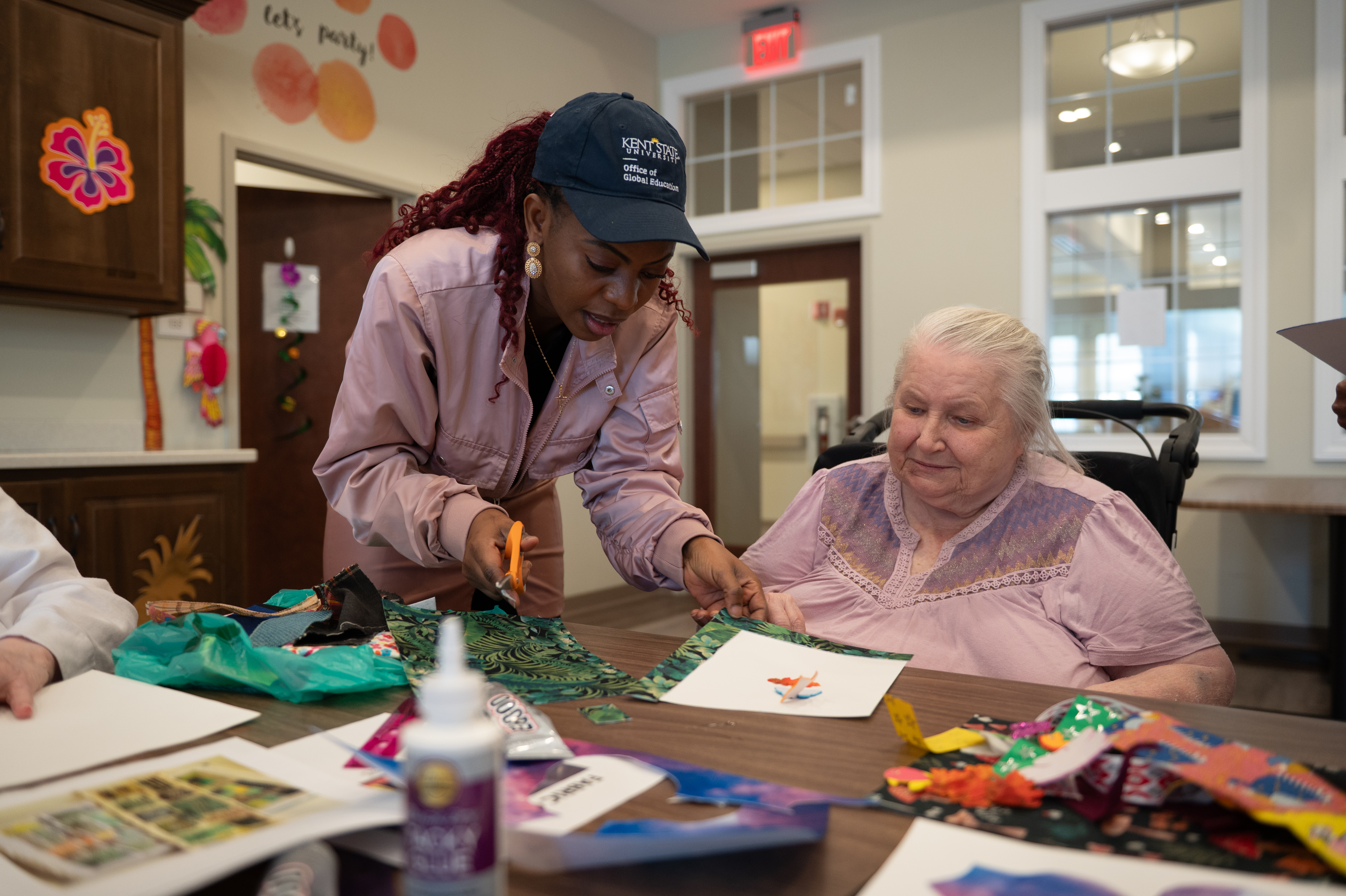 Adedayo Adeagbo (left) volunteering to help older adults at the Tamarack Ridge facility