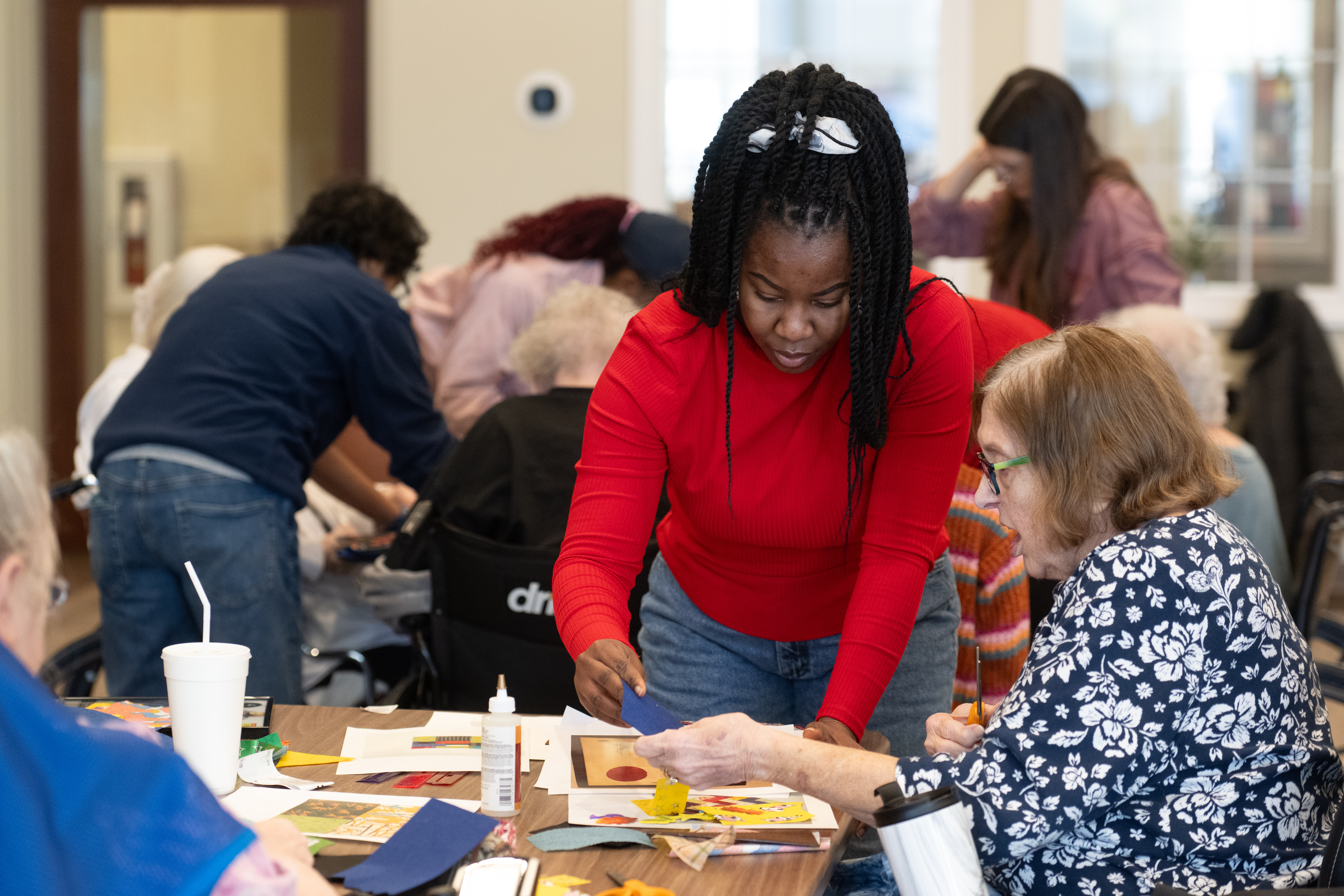 ����ֱ�� State students volunteer to assist residents with a craft project at Tamarack Ridge