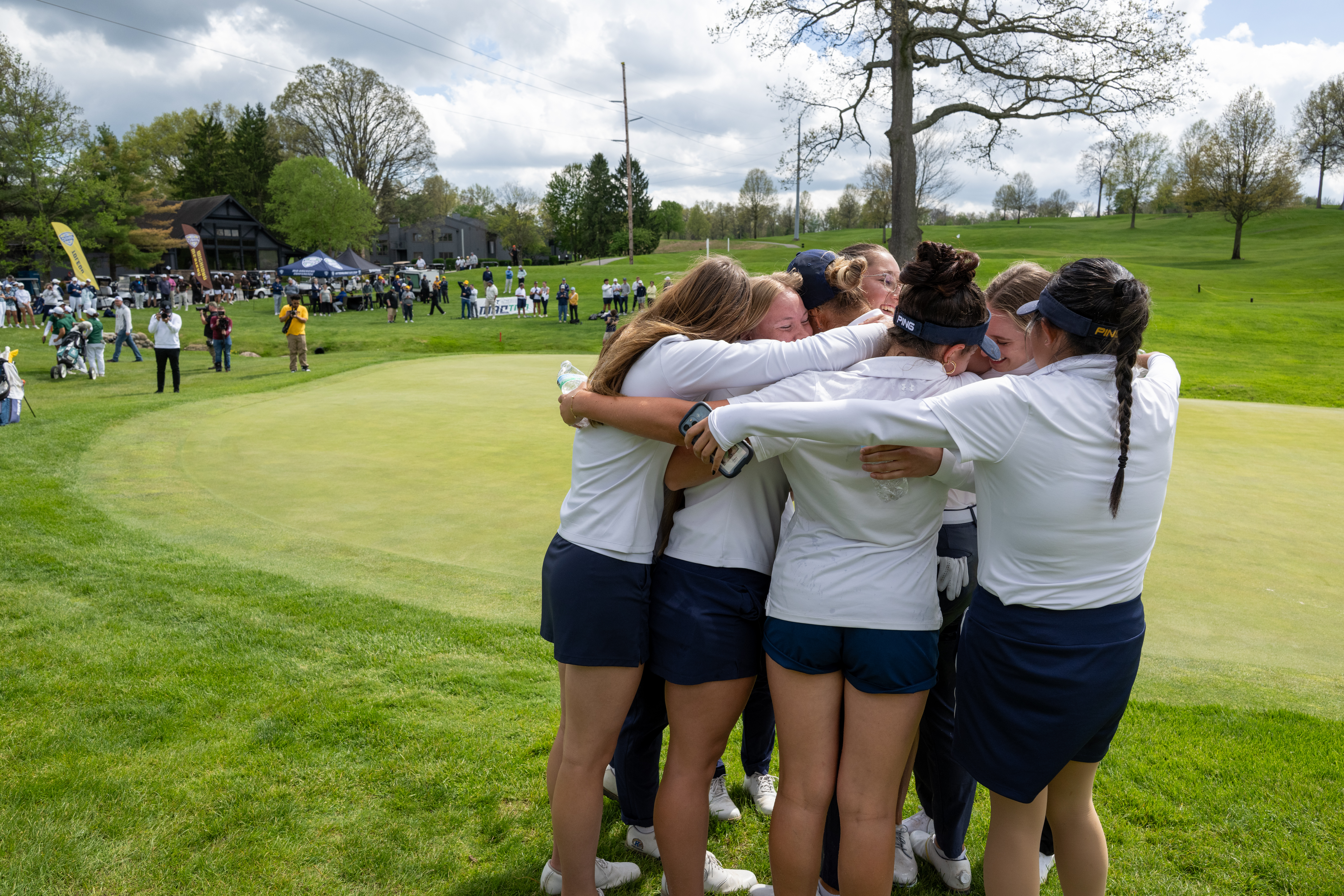 Women's golf team hugging each other at MAC championship