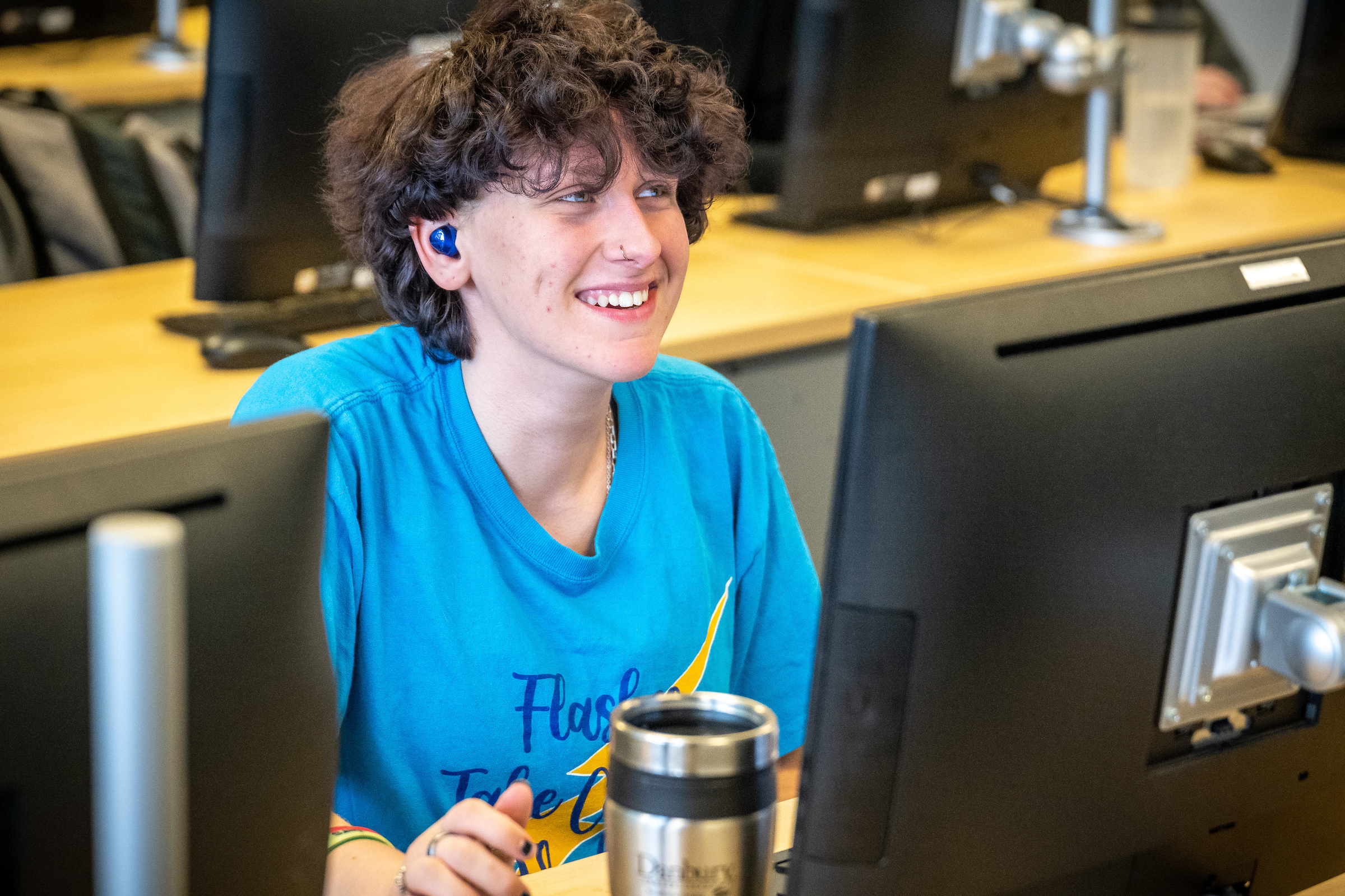 Student smiles at computer