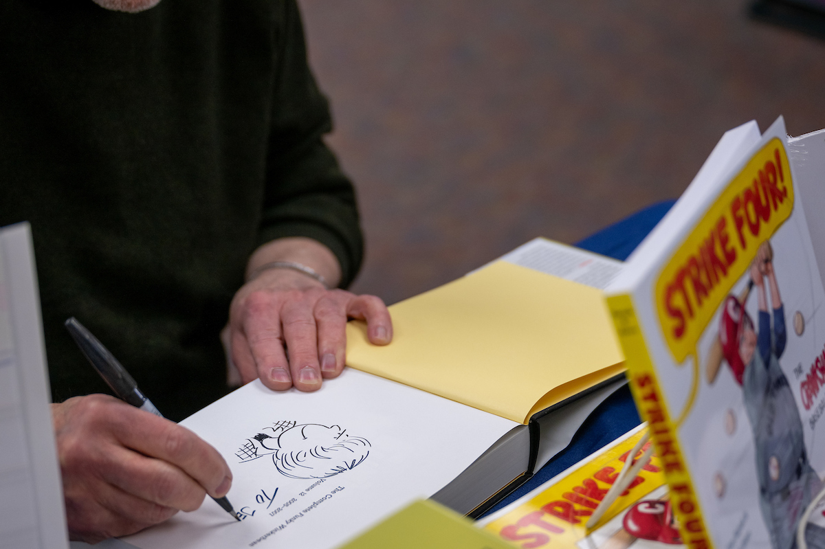 Cartoonist Tom Batiuk signs a copy of his Funky Winkerbean books at the Kent State University Book Store.