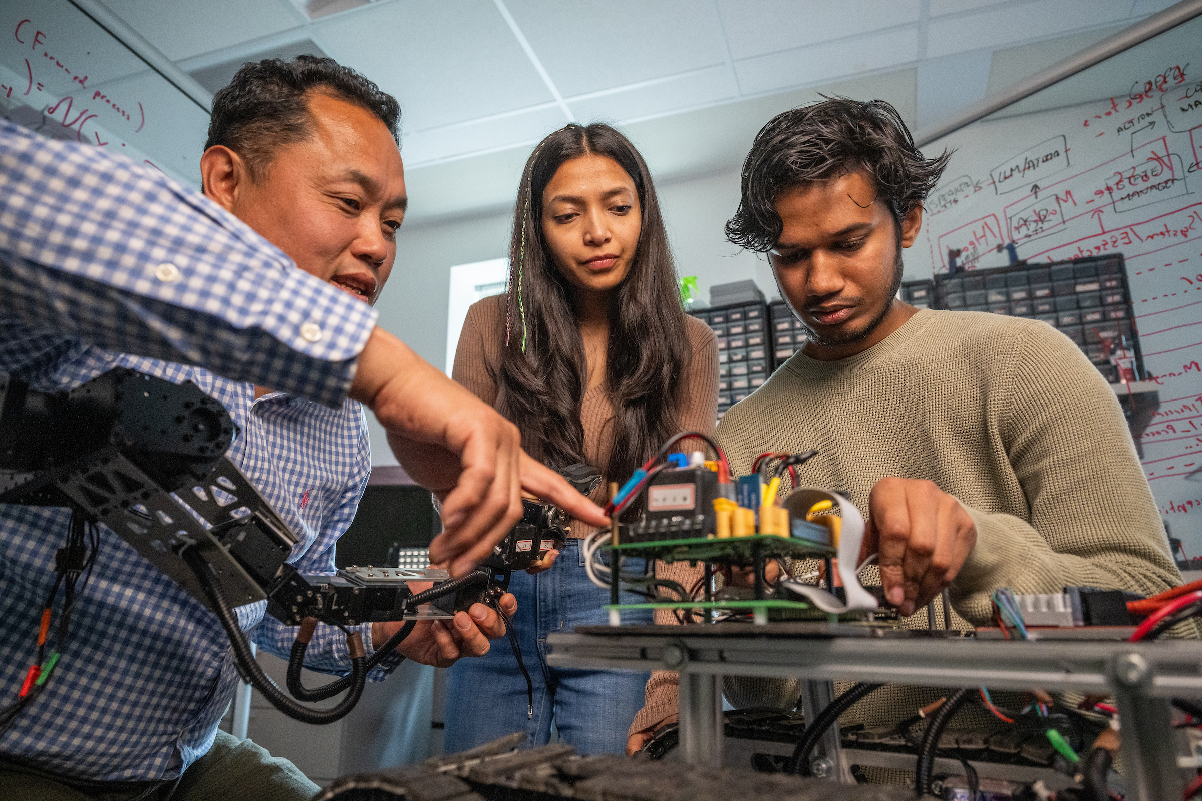 A professor with ֱ State's Department of Computer Science works with students on a research project
