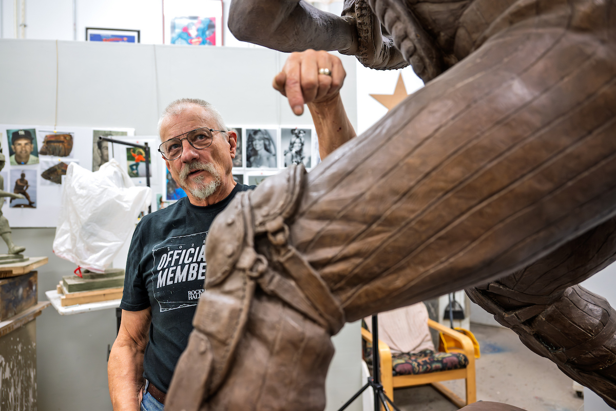 Dave Demming in his sculpture studio with statue of Thurman Munson