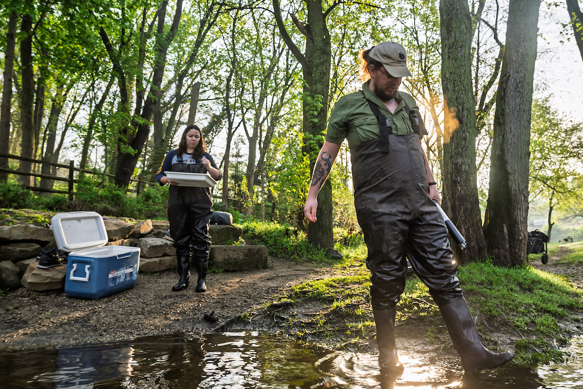 Students with samples walking into river water for David Costello's water research project