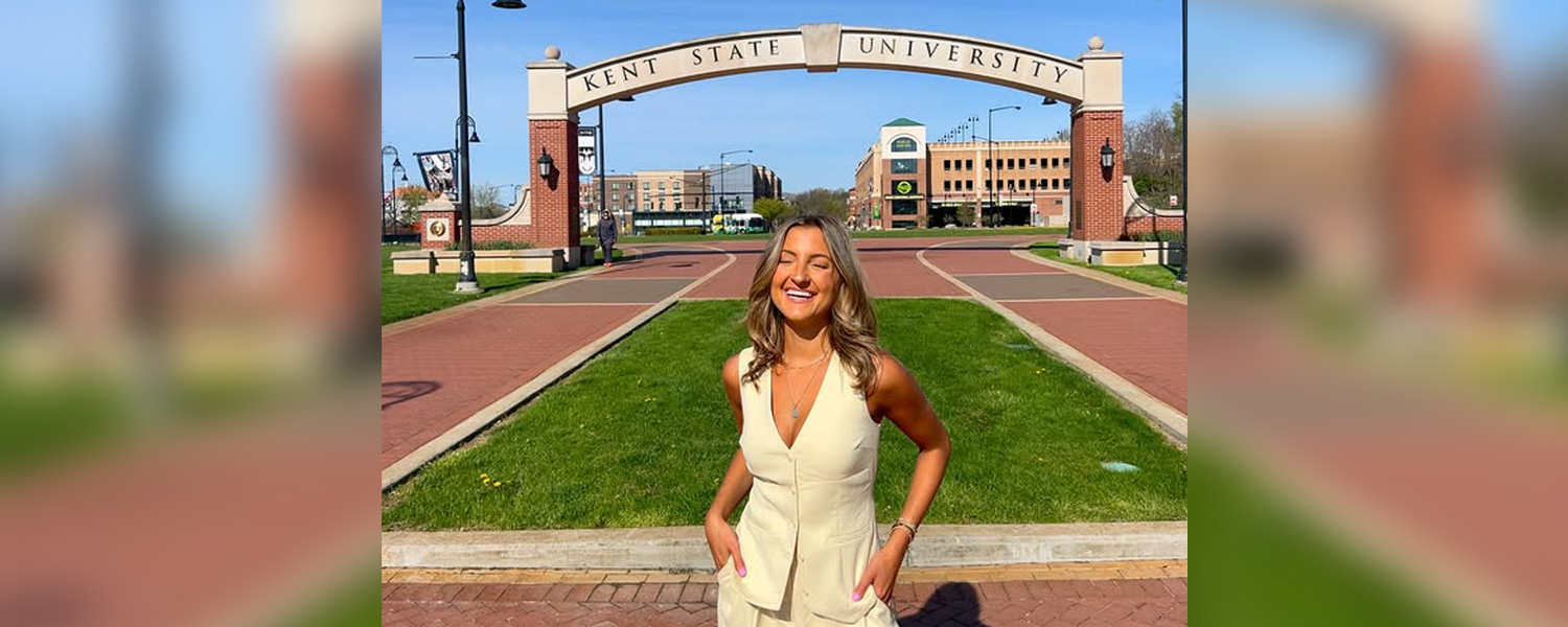 McKenzie Morgan standing in front of the Kent State University arch over the esplanade.
