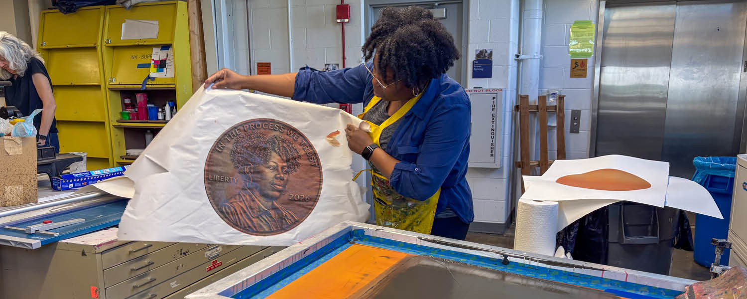 Tyanna holds up a print of her face on a coin