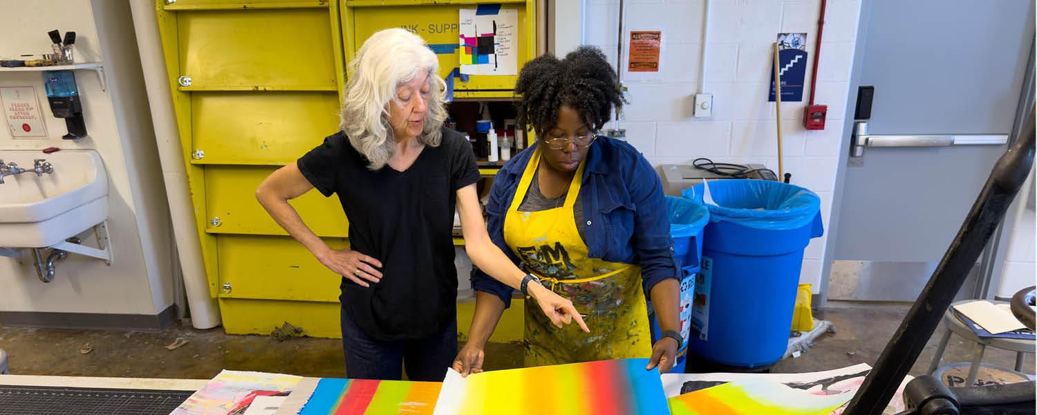 Participant gestures towards a sheet with multiple bands of color as Tyanna observes