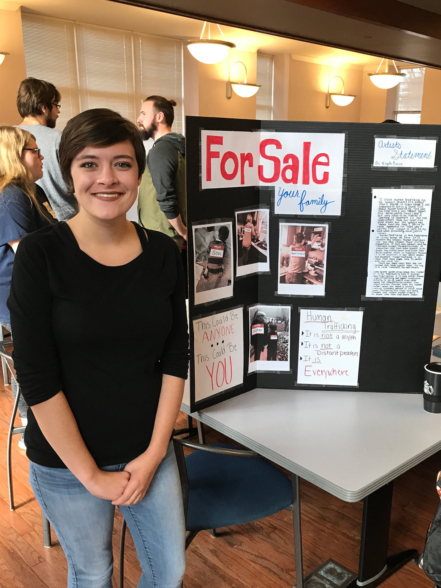 Student standing next to presentation board headed For Sale