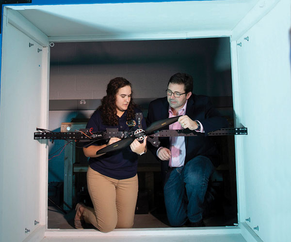 Blake Stringer, PhD, and a student test a drone.