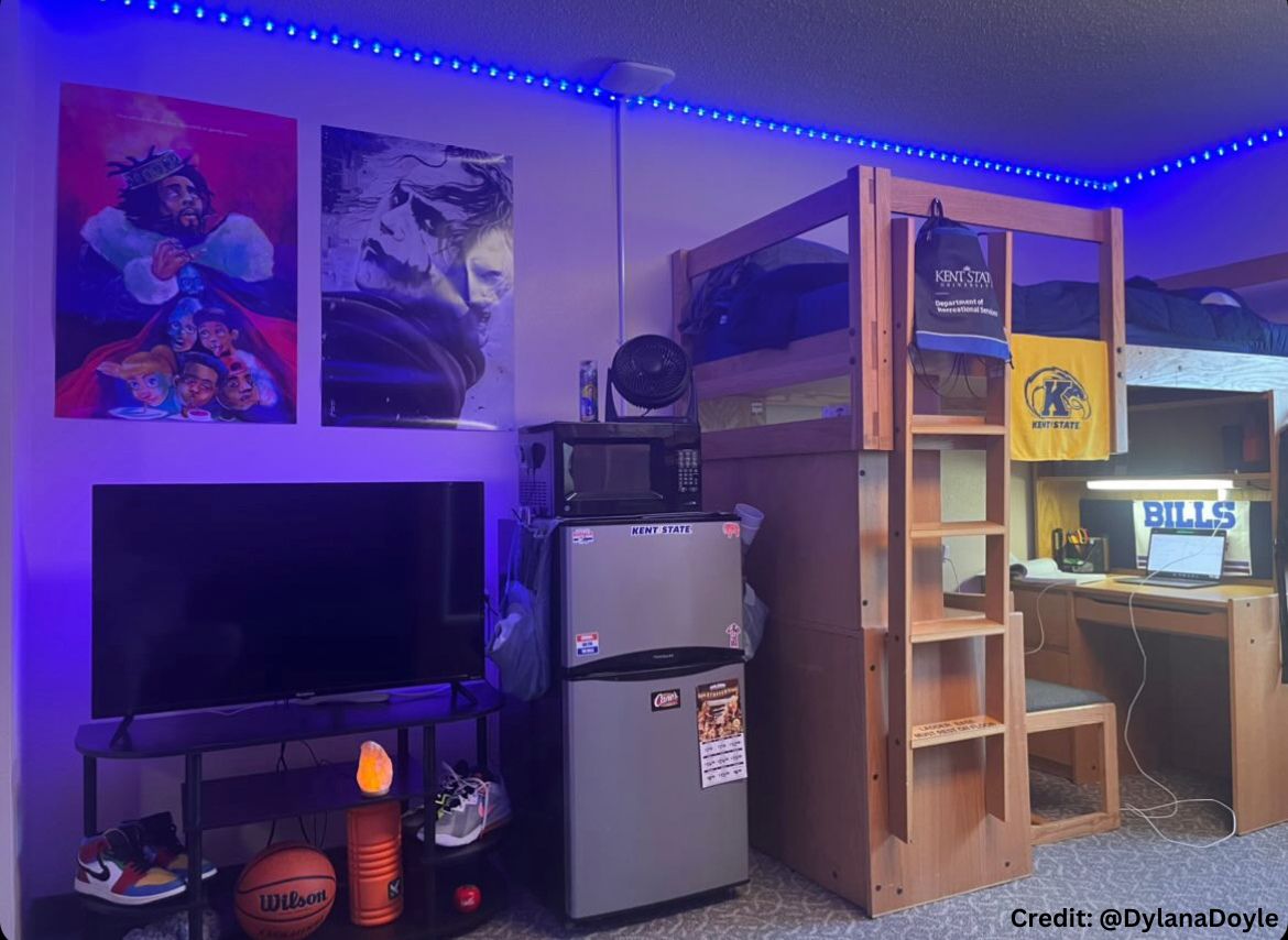 A dorm room with blue LED lights decorated with posters on the wall.