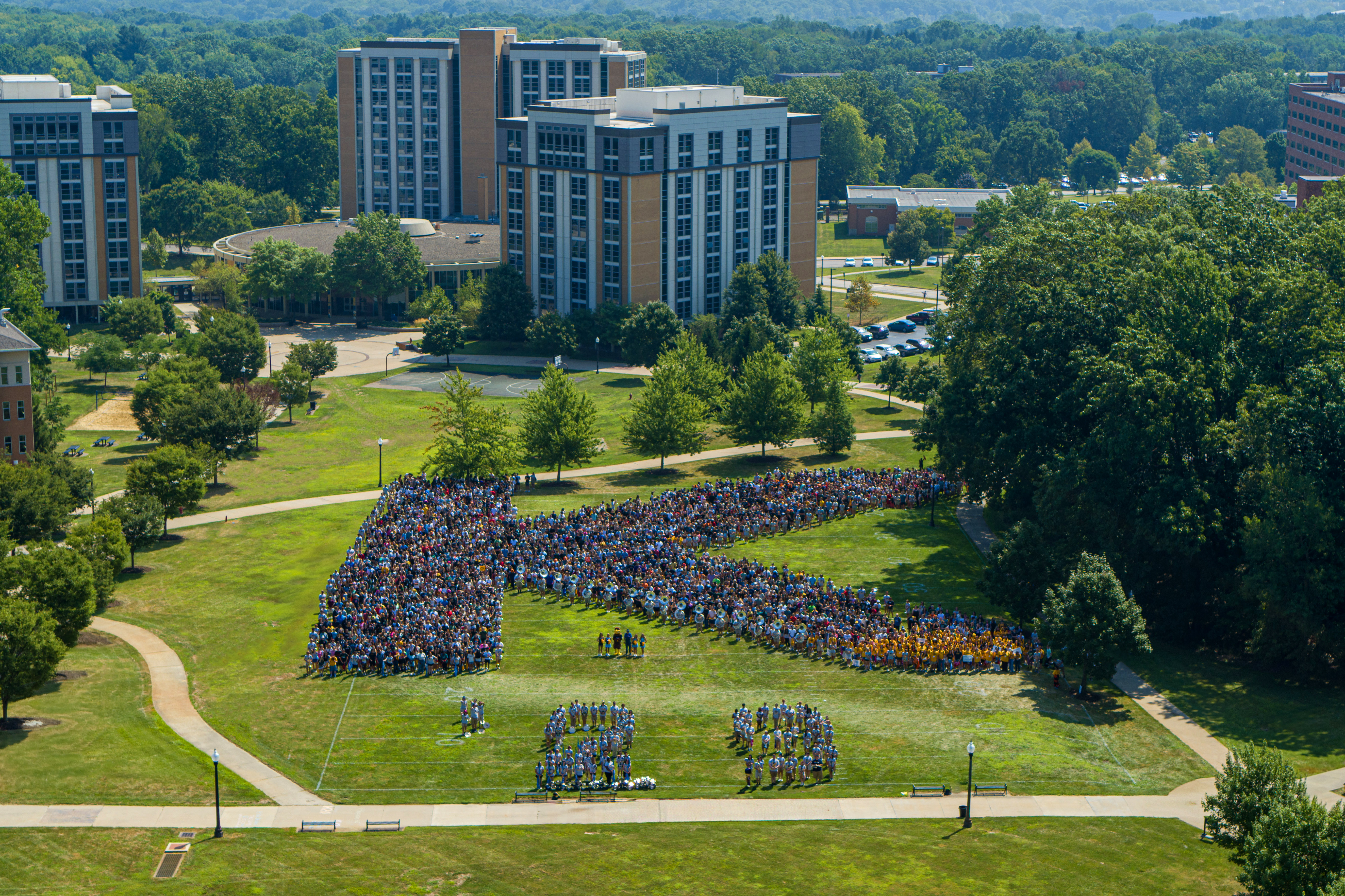Students stand in the grass to form the shape of a K