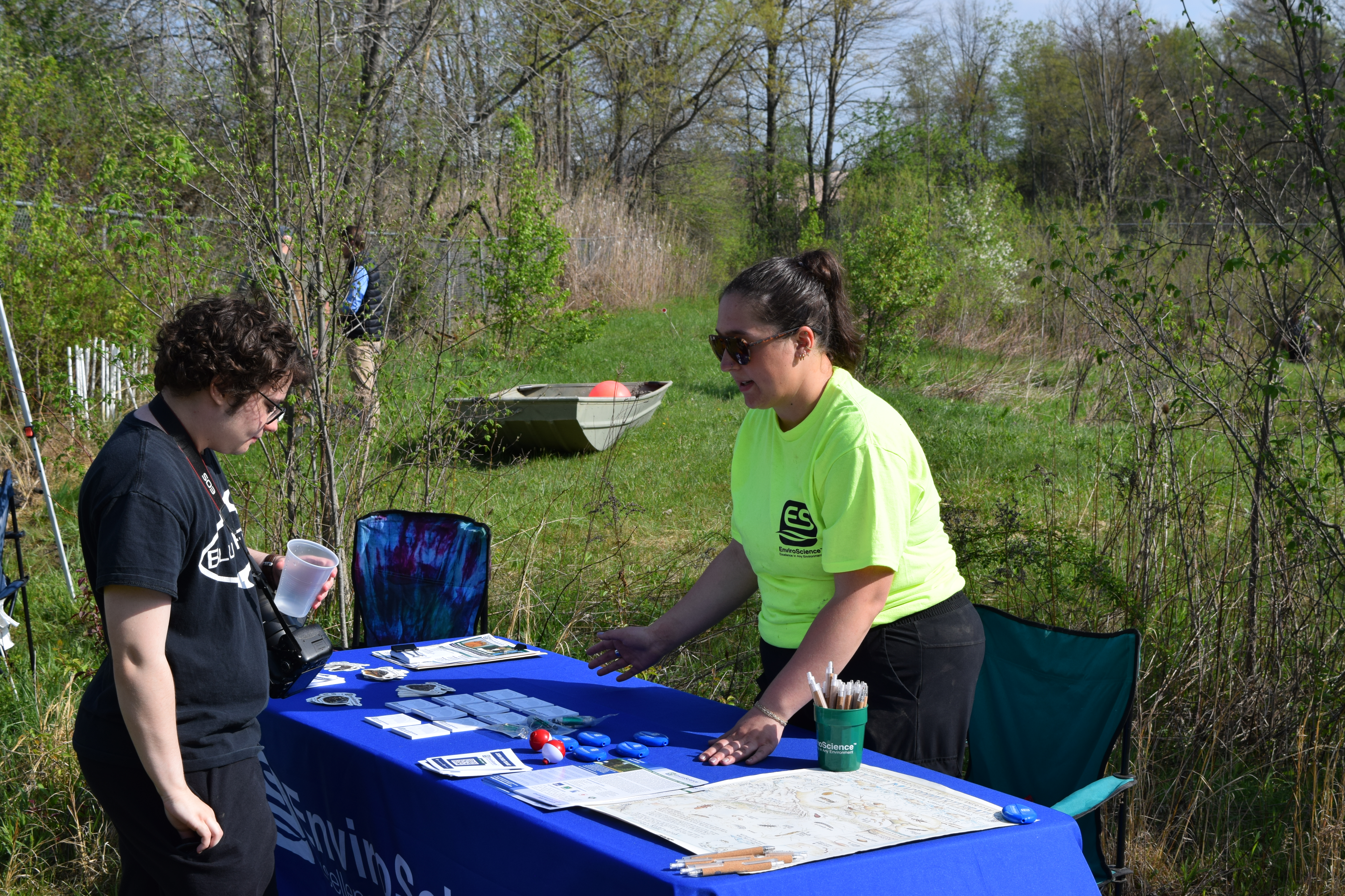 A student meets with a representative from the EnviroScience company at a information table 