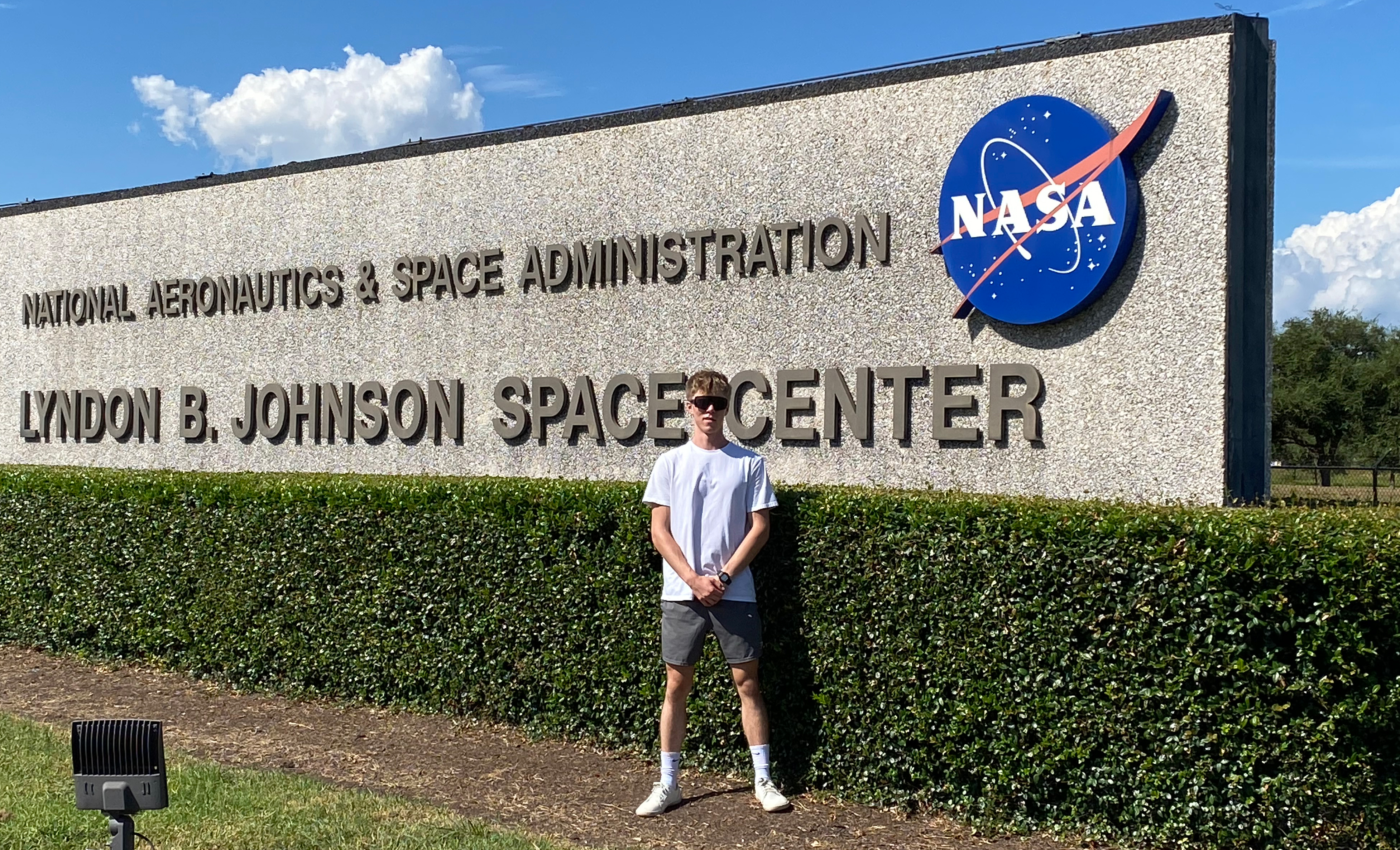 Ethan stands in front of the Lyndon B. Johnson Space Center sign at his internship