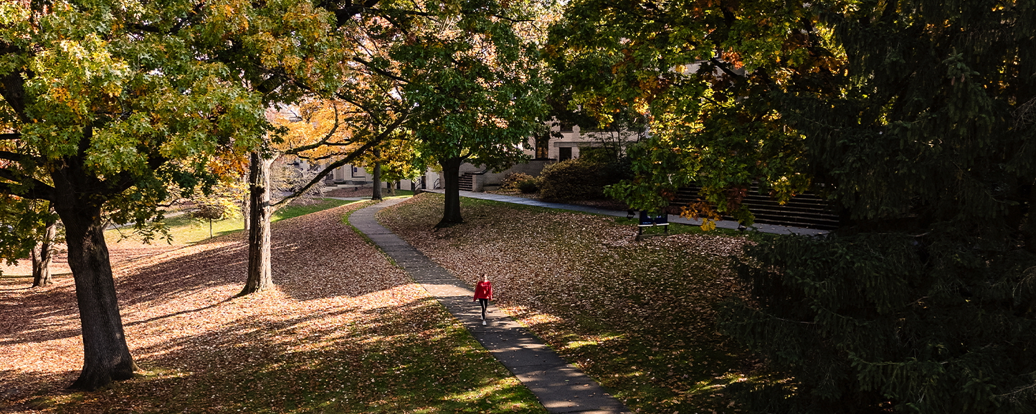 A Kent State student walks through fallen leaves on Front Campus