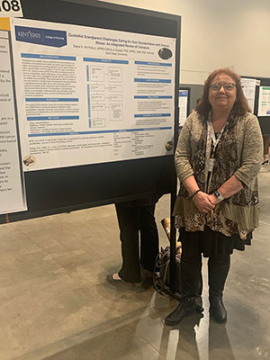 Diane Hill with her research poster. Diane Hill with her research poster.