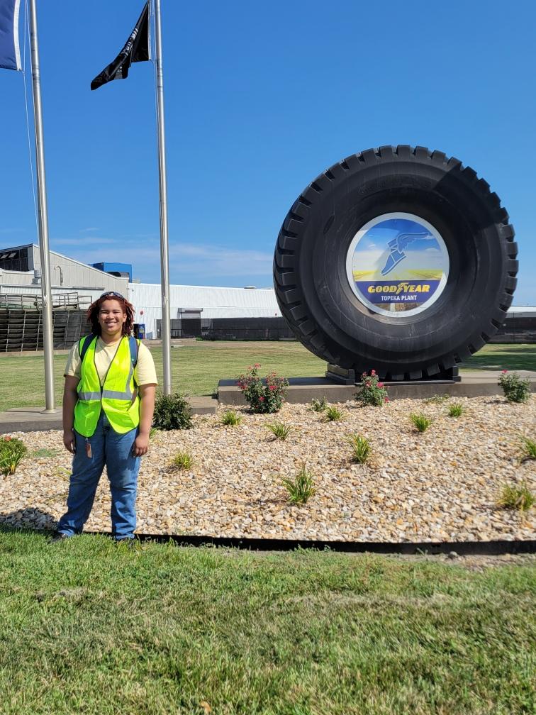 A photo of Guinn standing in front of a Goodyear Tires sign.