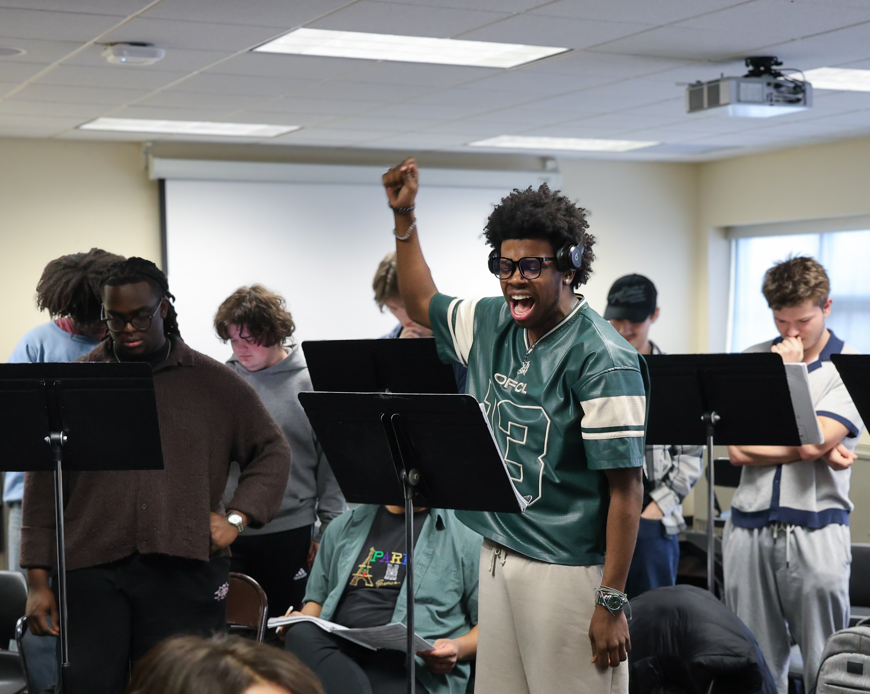 A class of musical theatre students sing along to scores of music
