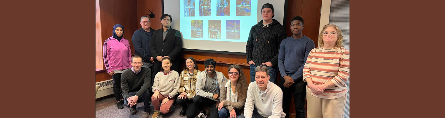 Faculty and students posing in front of screen