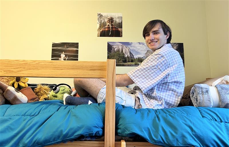 Honors student Lucas Hlavacek sittings in his residence hall room at .