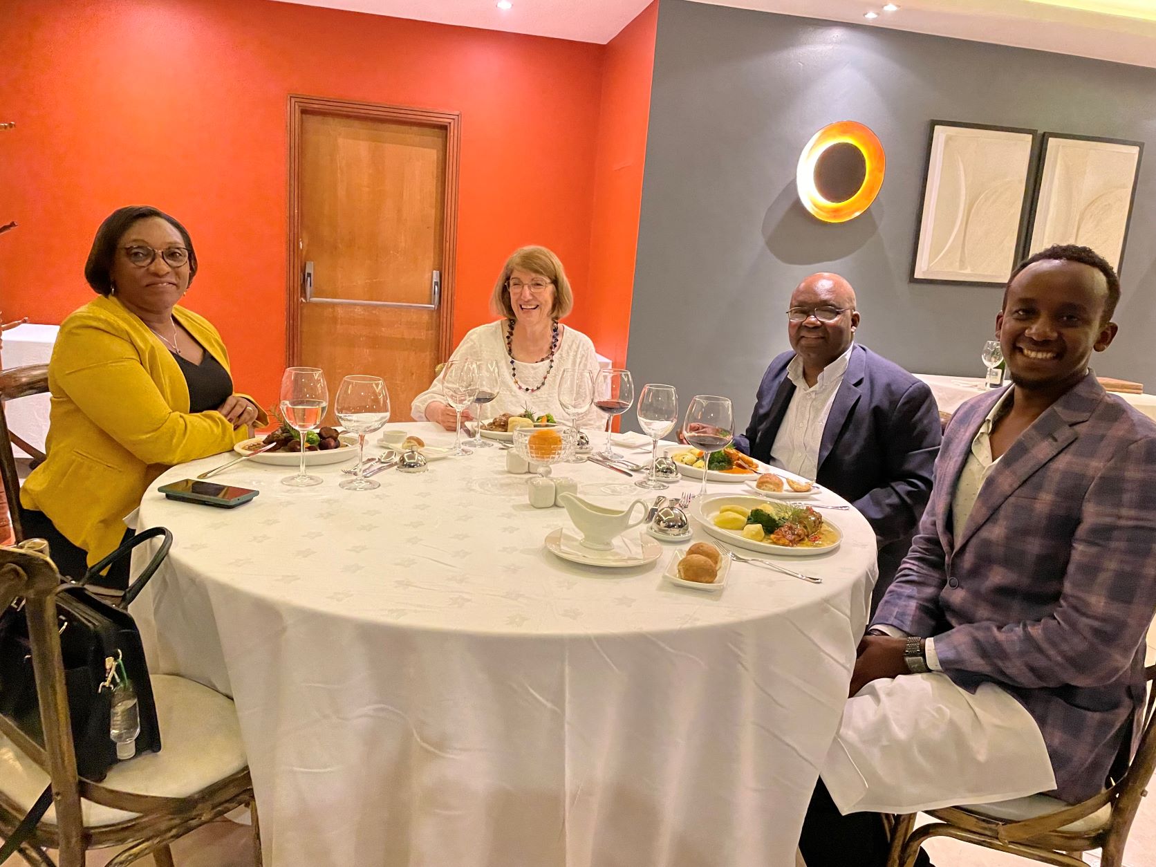 From left, Rwandan Minister of Education Valentine Uwamariya, СƬƵ Professors Joanne Caniglia and Davison Mupinga and СƬƵ Graduate Assistant and Rwandan native Pacifique Niyonzima, enjoy dinner during their May visit to the African nation.