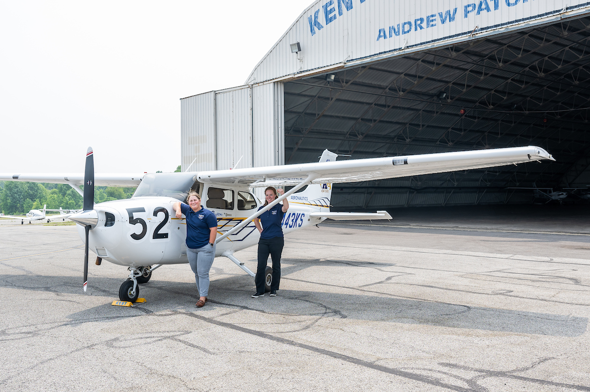 СƬƵ pilots stand by a plane at the СƬƵ Airport.