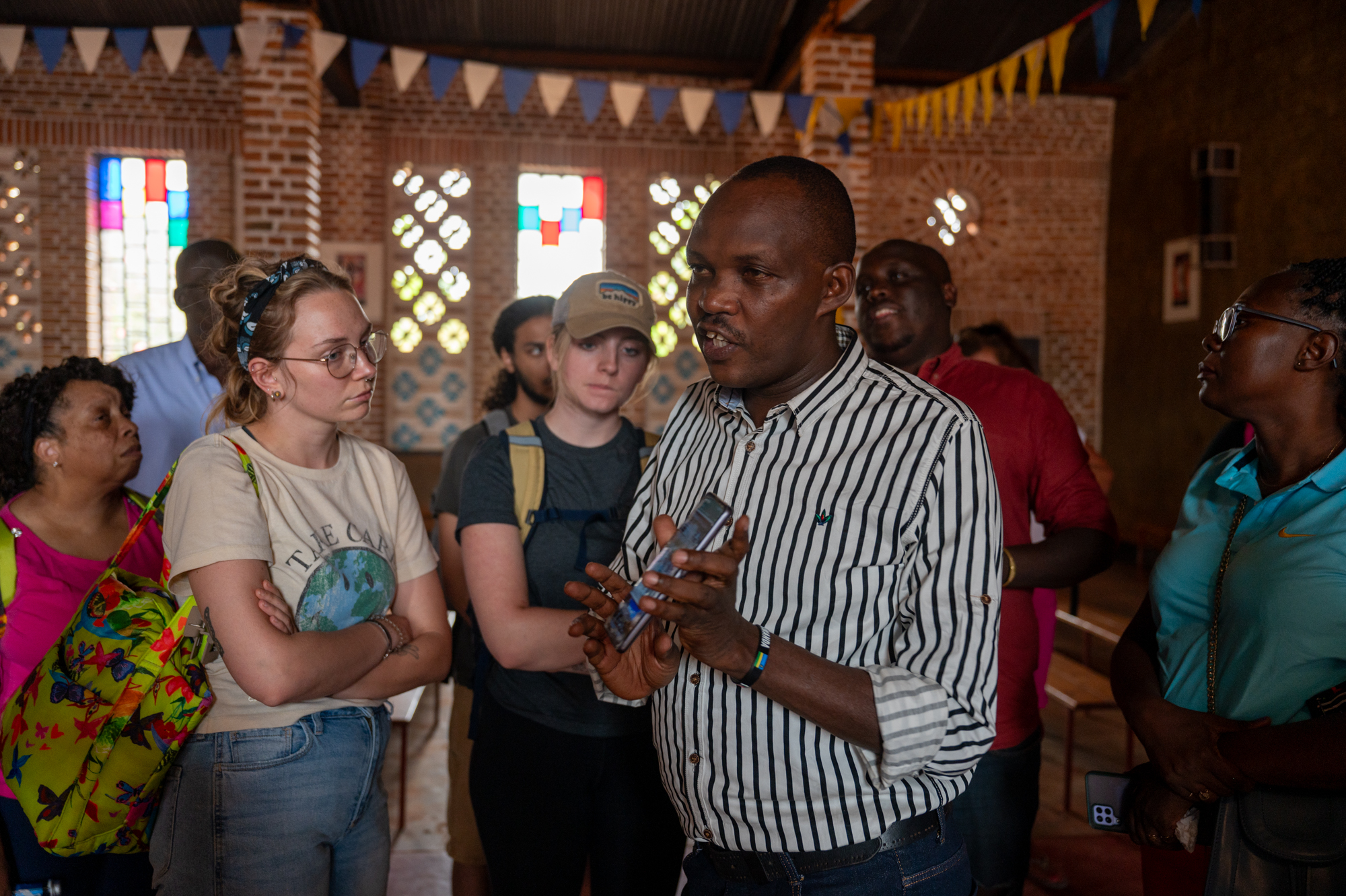 Lilian Keister, left, listens during a visit to a Rwandan church as part of the Kigali Summer Institute.