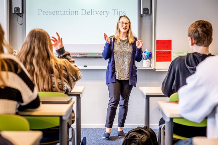 Madison teaching at the front of a classroom, students are seated at desks.