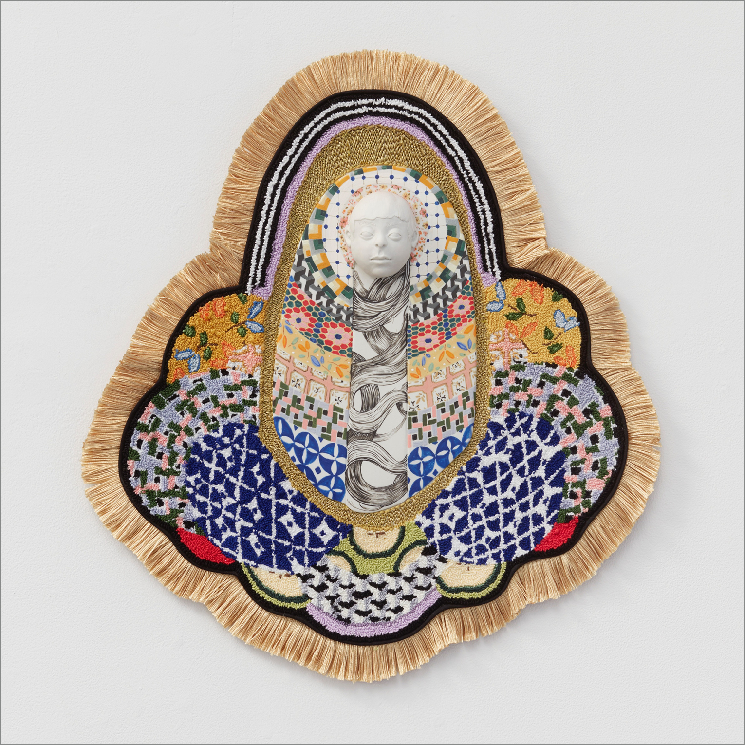 A multitude of patterns and textiles conjoin in a center point where a white sculpted face lies
