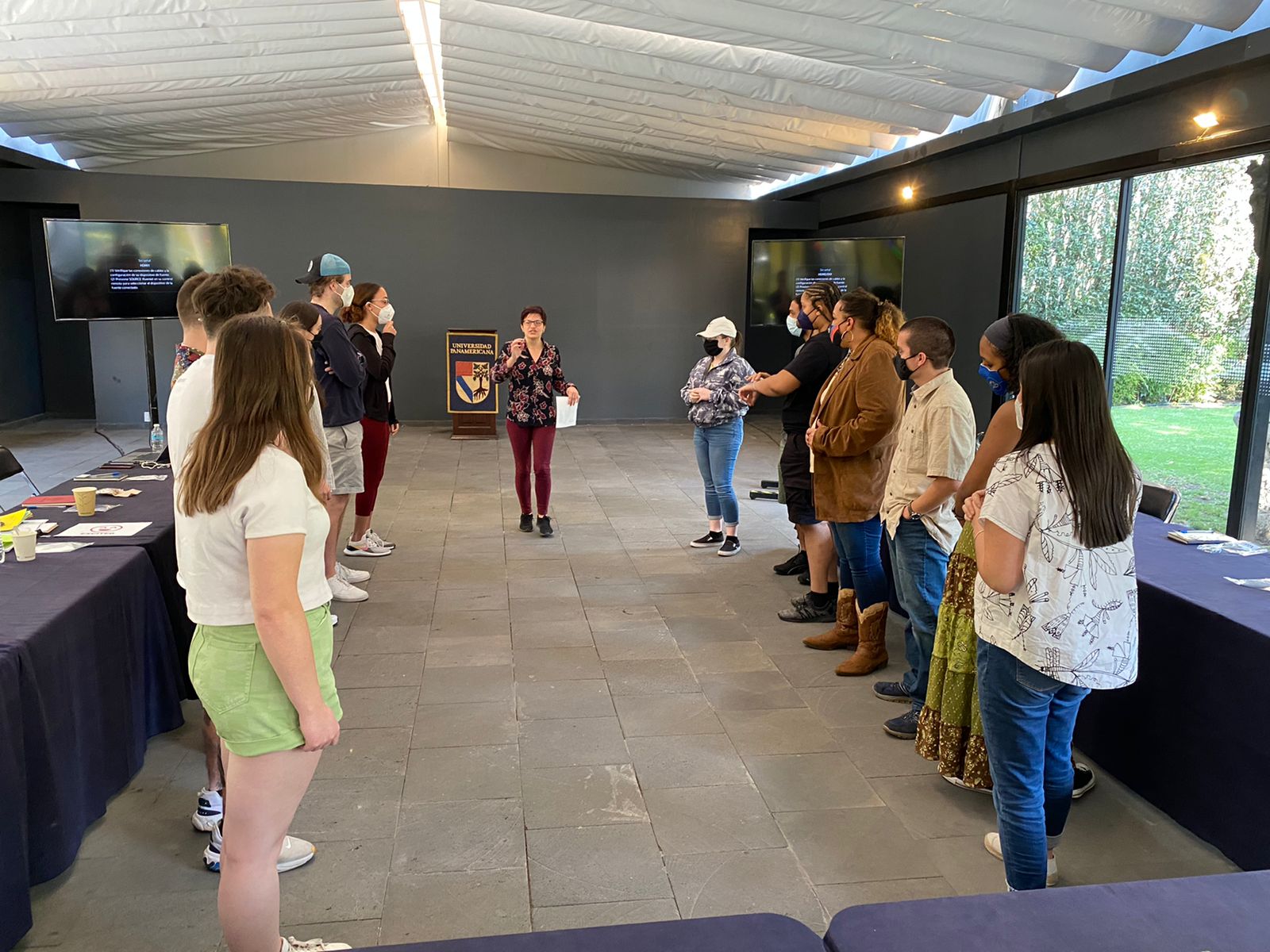 Students and faculty during a class session in Mexico City. Everyone is standing in two lines while Sarah Schmidt provides directions from the middle.