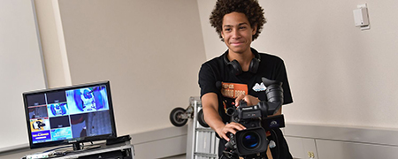 A Firestone Community Learning Center student learns how to operate a video camera during a class in Franklin Hall, home to Kent State University’s School of Journalism and Mass Communication.