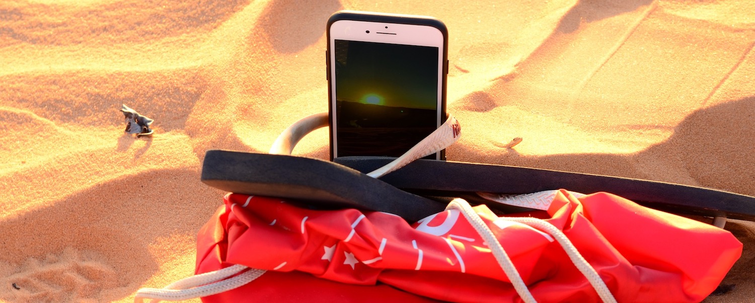 Phone in beachbag on sand