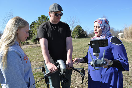 Receiving up-close instruction on operating the drone are (from left) Alicia Costello and Fred Hausser from Dr. Sheren Farag.