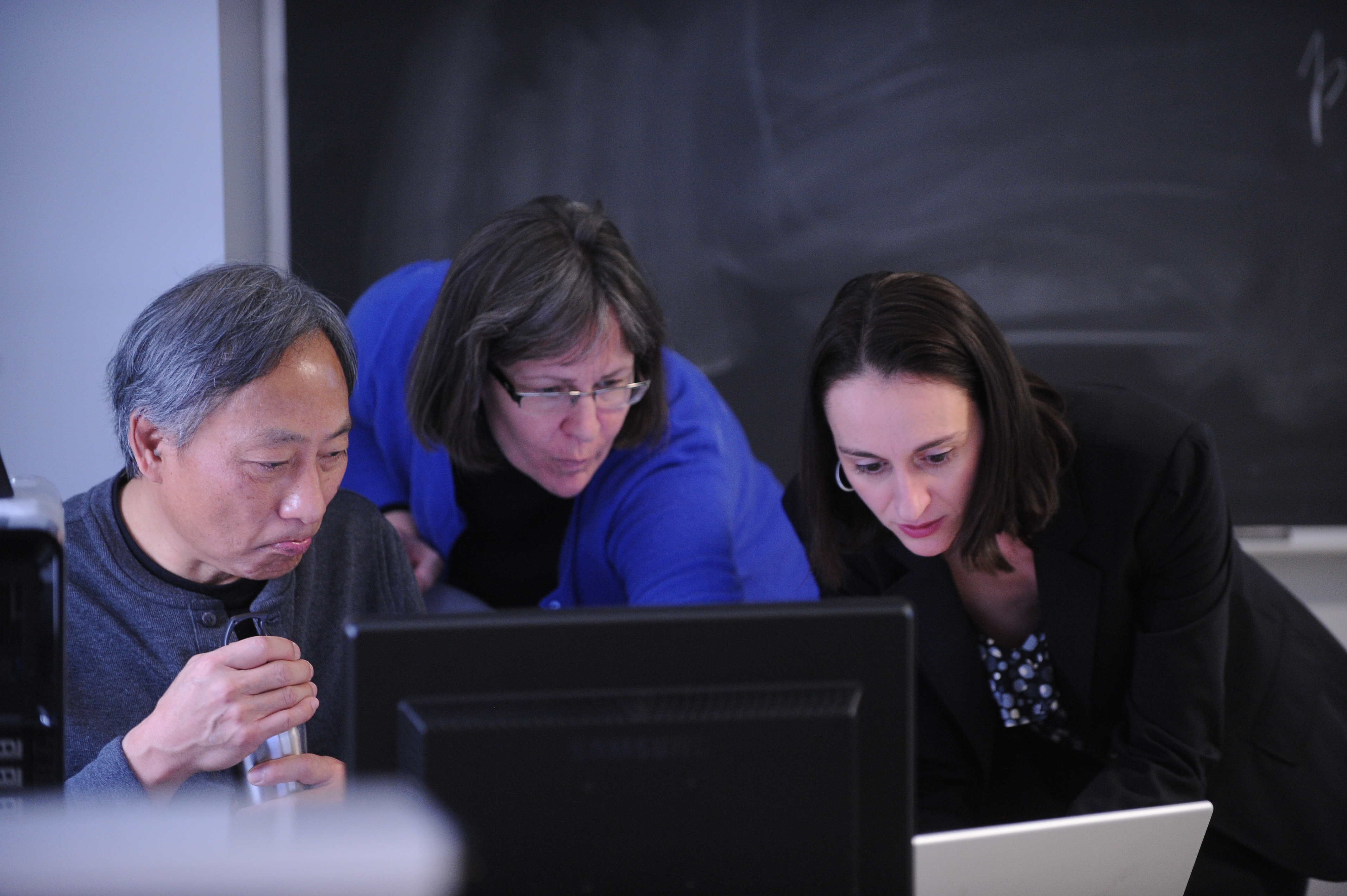 Suzan Zake helping journalists on computer