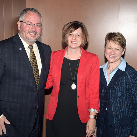 Sarah Sigler (center), associate director of prospect research in Prospect Management and Research, receives the 2018 President’s Award of Distinction from 鶹ý President Beverly J. Warren. They are pictured with Vice President for Institutional Advancement Stephen Sokany (left).