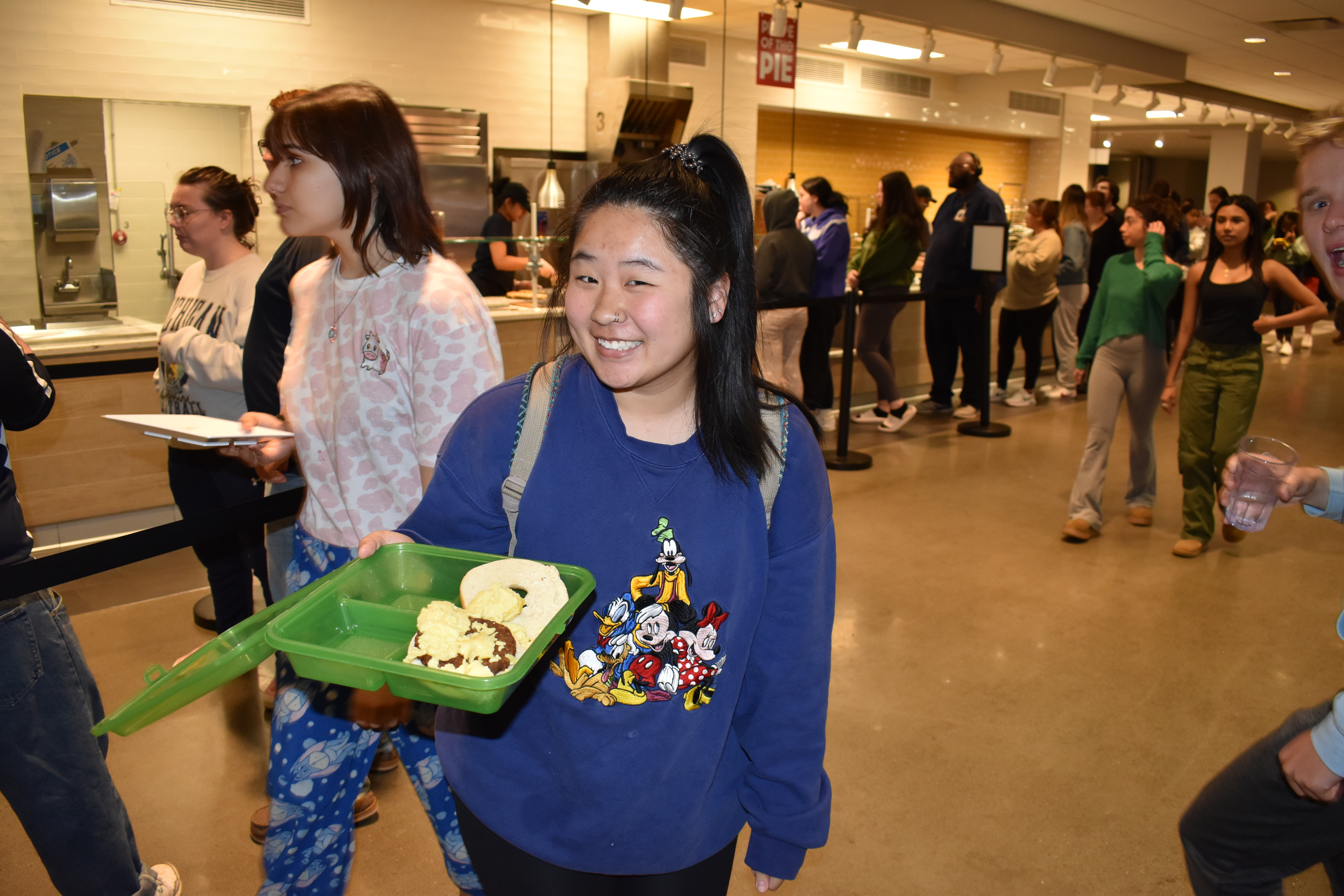 Female KSU Student smiling while holding an open OZZI container filled with food