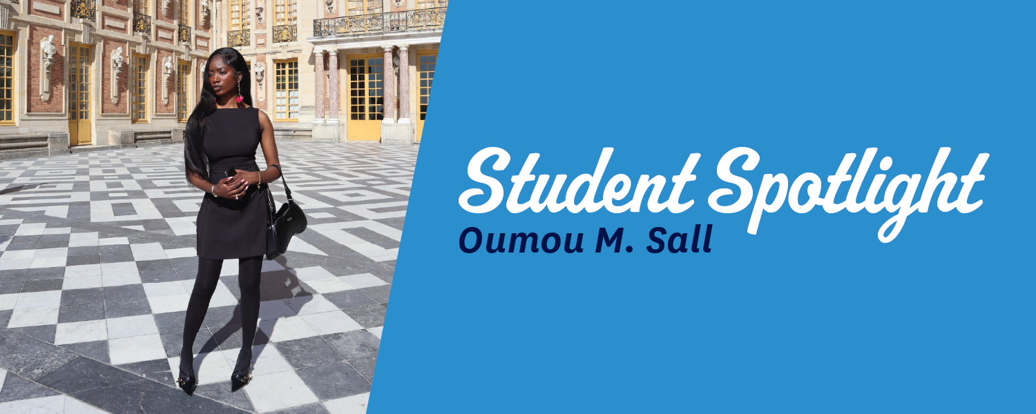 Oumou standing in the center of outdoor buildings on a checkered floor
