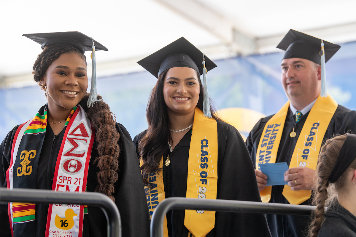 New ɫֱ graduates line up to cross the stage and receive their diplomas.