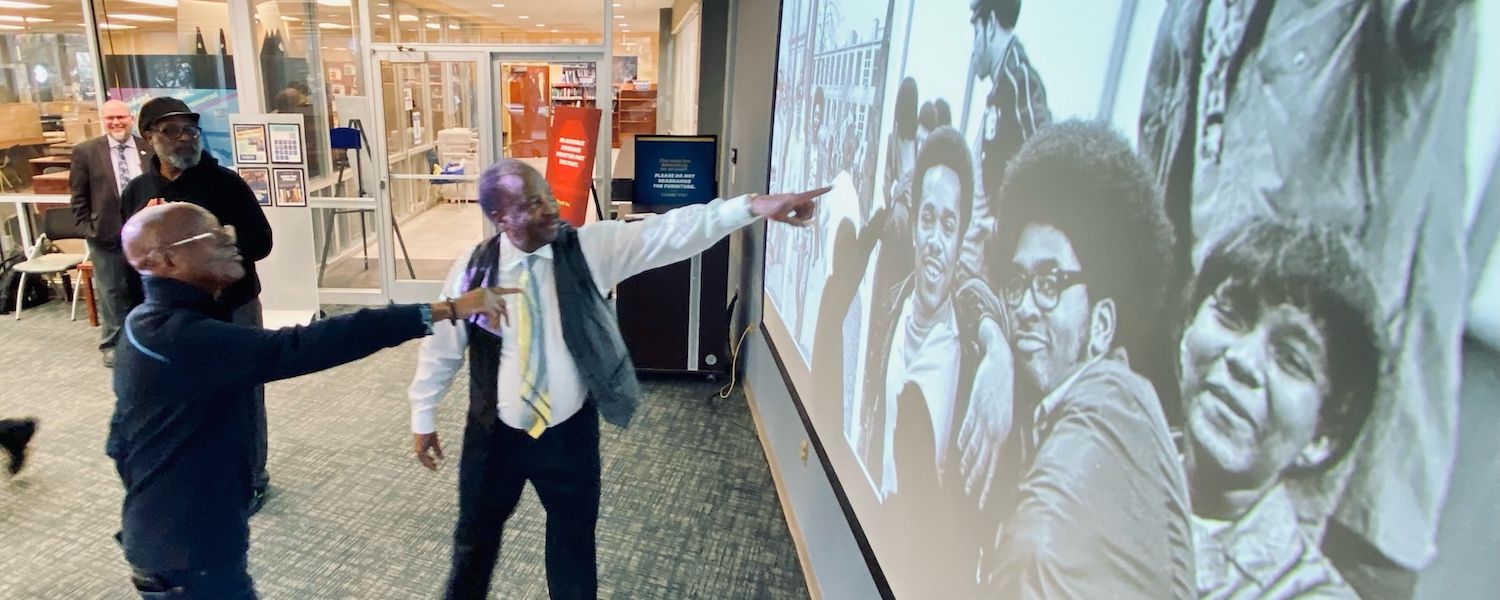 Lafayette Tolliver and Gene Shelton identify people in photos on the screen