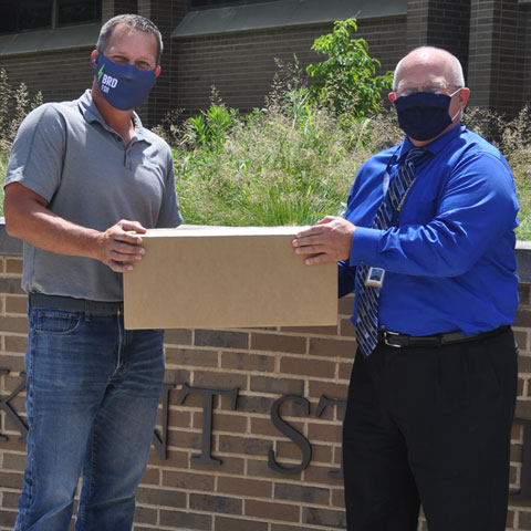 Matt Zines, program engineer at Ventra Salem and a KSU alum, hands over a carton of face shields to Dr. David Dees, dean and CAO of the Columbiana County campuses. Matt Zines, program engineer at Ventra Salem and a KSU alum, hands over a carton of face shields to Dr. David Dees, dean and CAO of the Columbiana County campuses.