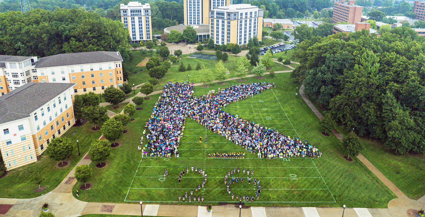 Students forming the letter "K" on campus.