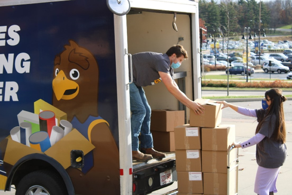 Volunteer students loading boxes of food into the Division of Philanthropy and Alumni Engagement mobile unit