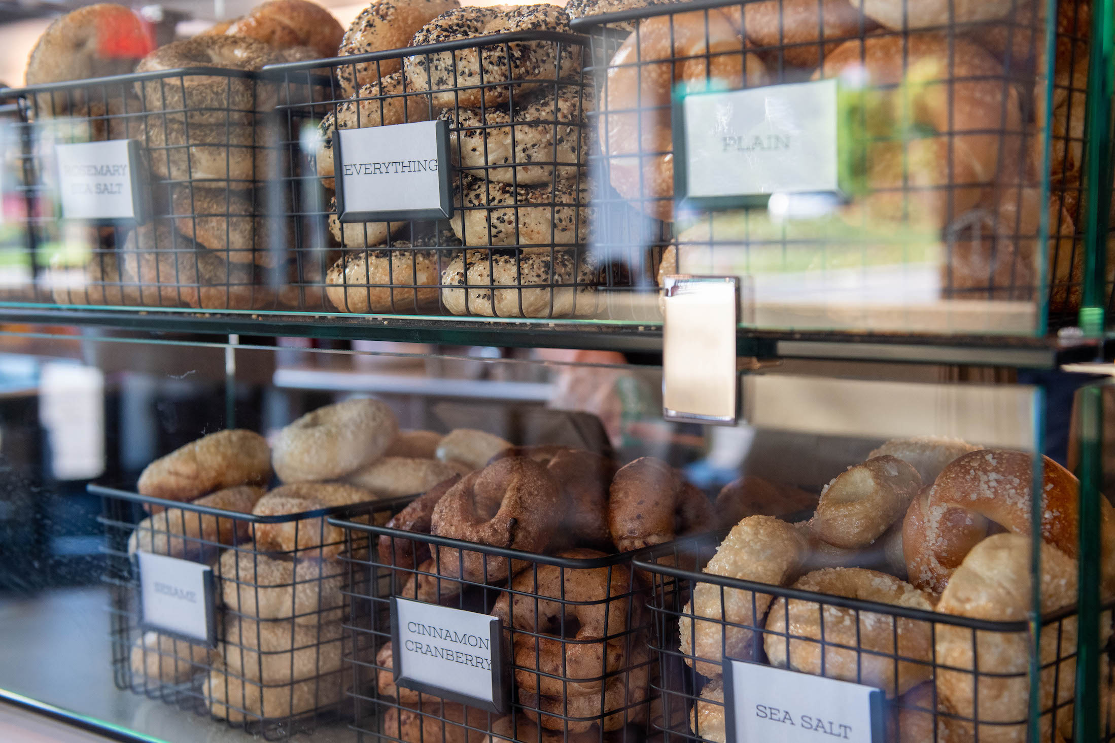 Selection of different bagels in display case. 