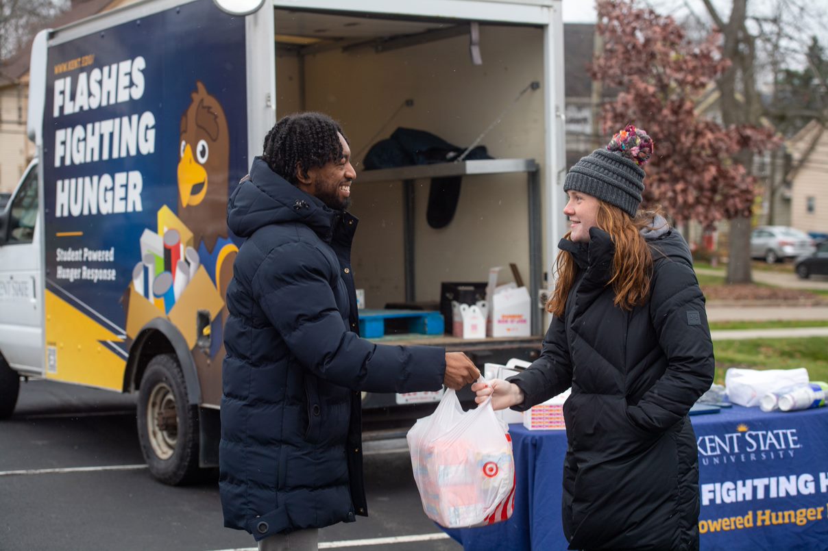 Student handing over donations to volunteer