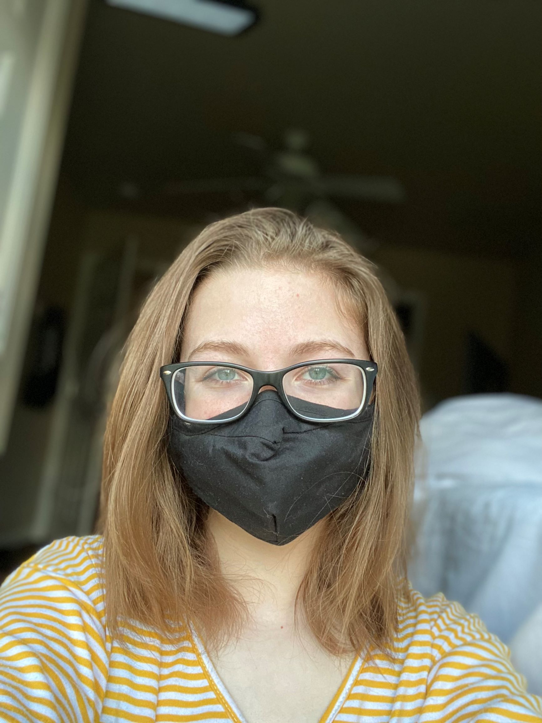 Olivia Farina wearing a mask in her apartment.