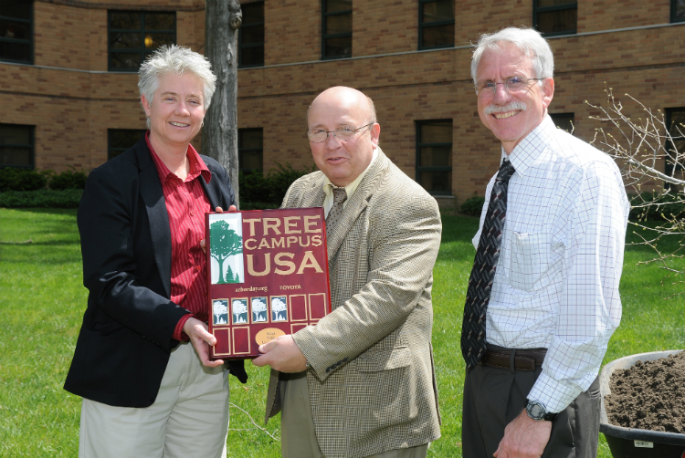 Heather White, Vice President Gregg Floyd and Tom Euclid accept Kent State’s designation as an official Tree Campus, during an Arbor Day tree-planting ceremony beside Engleman Hall.