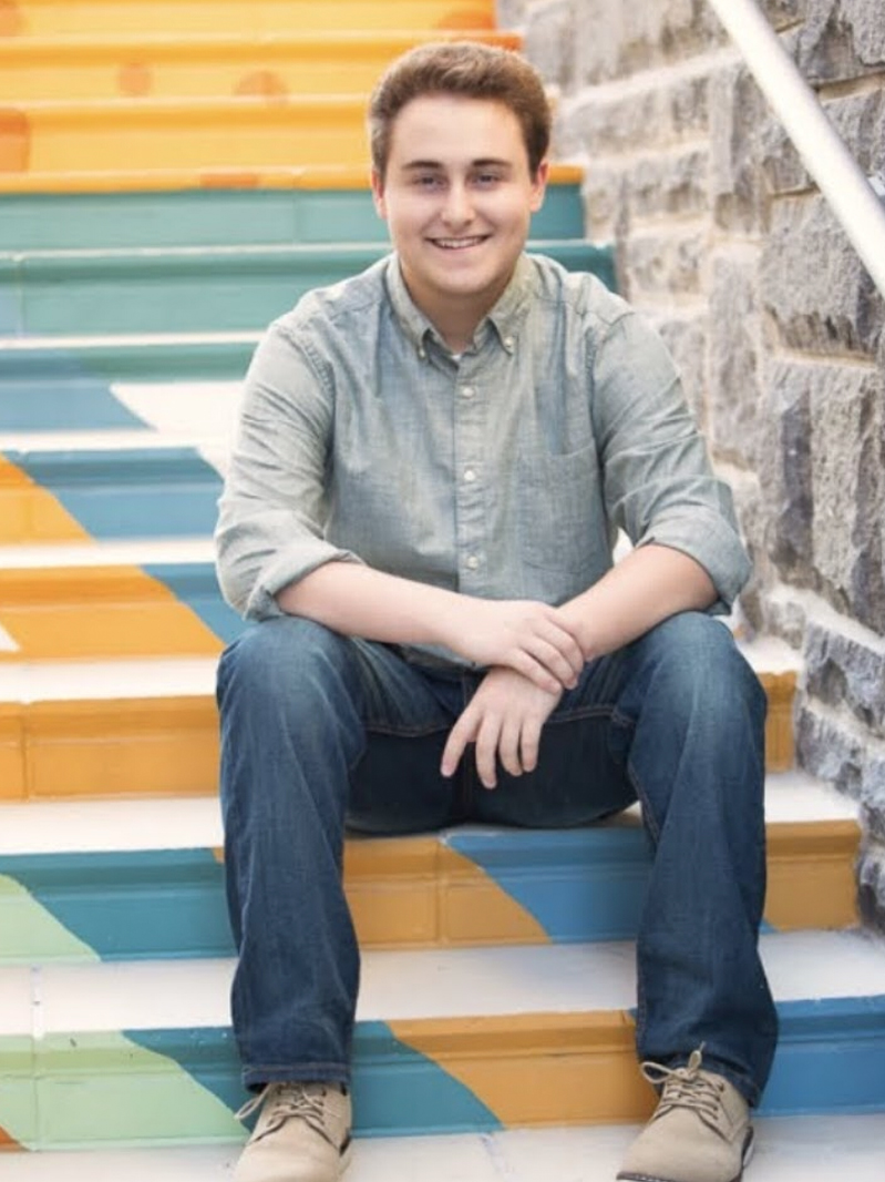 Andrew Aronoff sits on colorful steps.