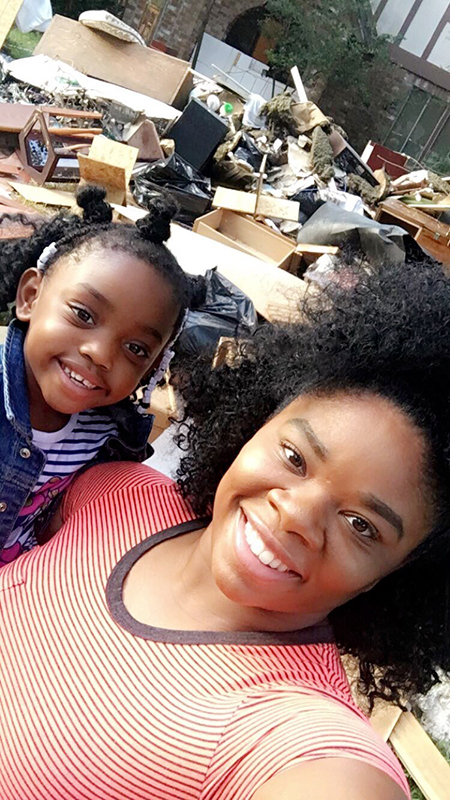 Posing with her daughter, 鶹ѡstudent Alexis Bartee takes a photo in front of her grandparents' storm-damaged house.